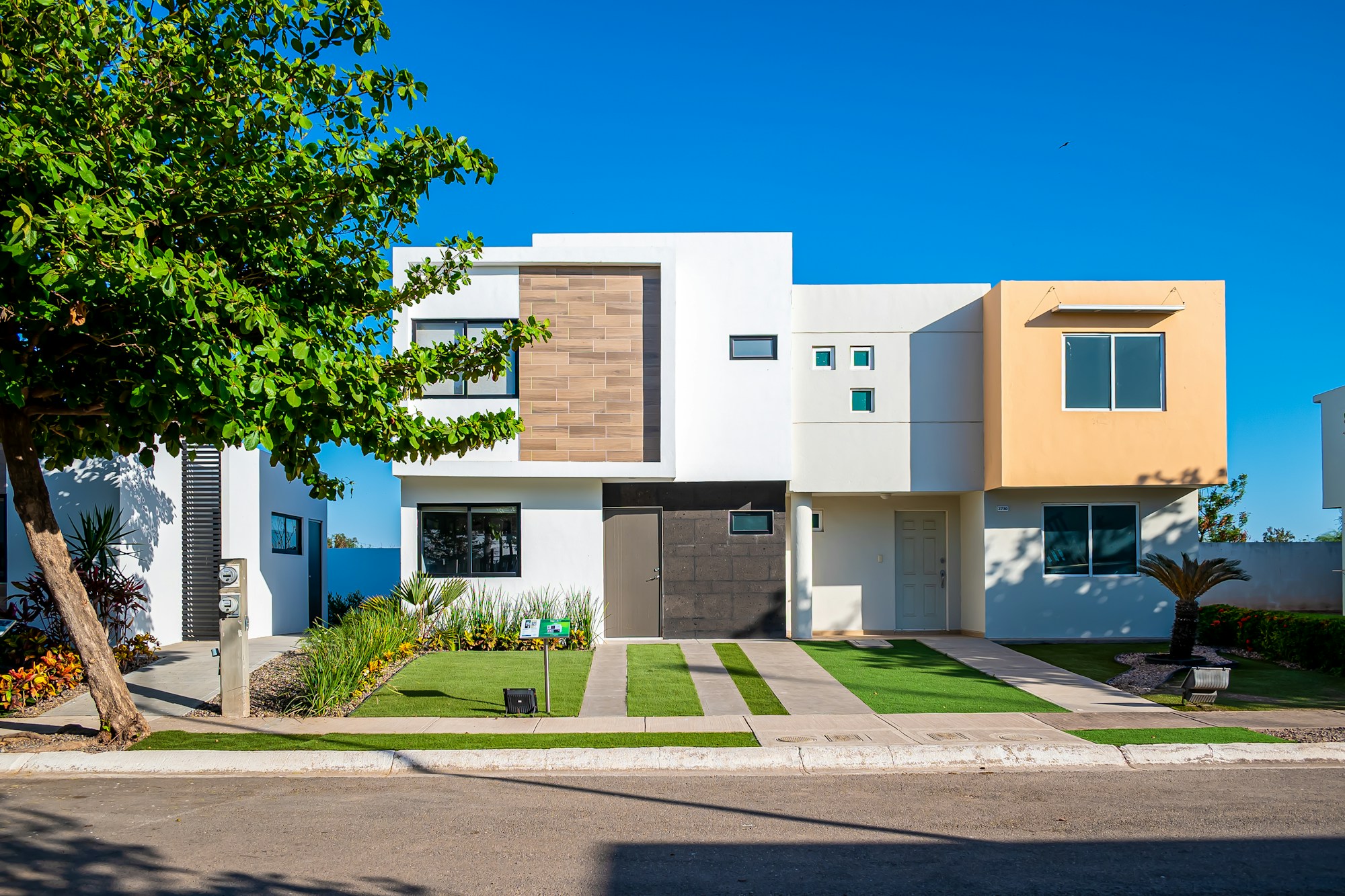 a white house with a tree in front of it