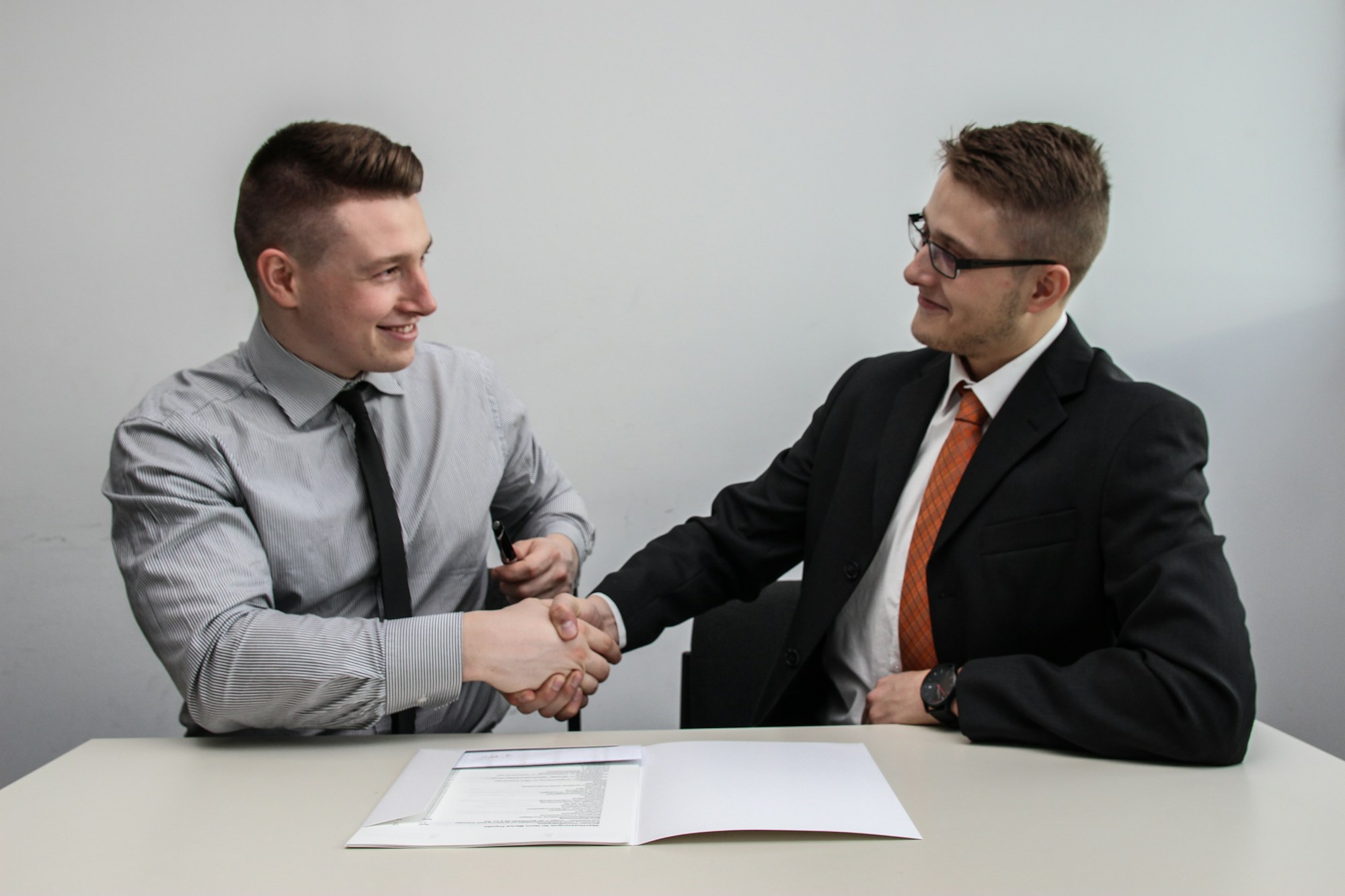 Broker guiding an applicant through the temporary real estate license process in an office setting.